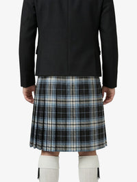 Person wearing a black jacket and plaid kilt on a white background