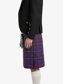 Person wearing a black blazer and red plaid kilt on a white background