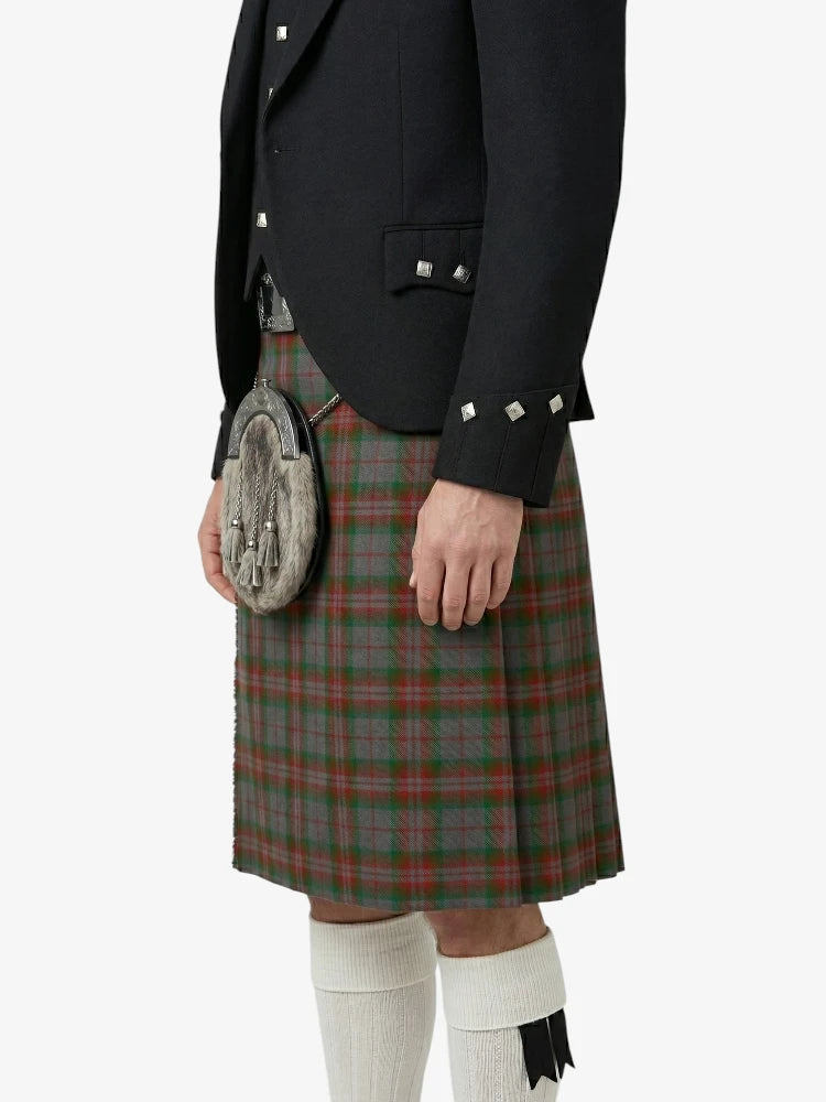 Person wearing a black jacket and red plaid kilt on a white background