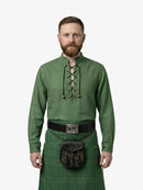 Man wearing a green historical outfit with a kilt on a white background