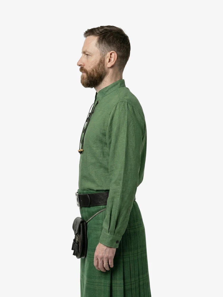 Man wearing a green outfit with a kilt on a white background