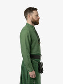 Man wearing a green traditional outfit with a kilt on a white background