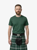 Man wearing a green kilt with a belt on a white background