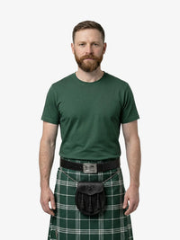 Man wearing a green kilt with a belt on a white background