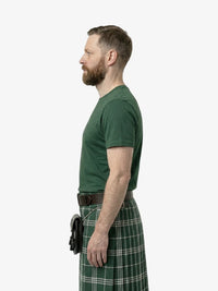 Man wearing a green t-shirt and green plaid kilt on a white background