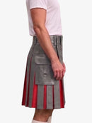 A side view of a person wearing a gray faux-leather pleated kilt with red vertical stripe accents and a large front flap pocket with a metal ring detail, paired with a white t-shirt and white socks, against a plain light gray background.
