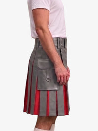 A side view of a person wearing a gray faux-leather pleated kilt with red vertical stripe accents and a large front flap pocket with a metal ring detail, paired with a white t-shirt and white socks, against a plain light gray background.