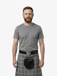 Man wearing a gray t-shirt and gray plaid kilt on a white background