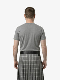 Man wearing a gray t-shirt and a gray plaid kilt on a white background