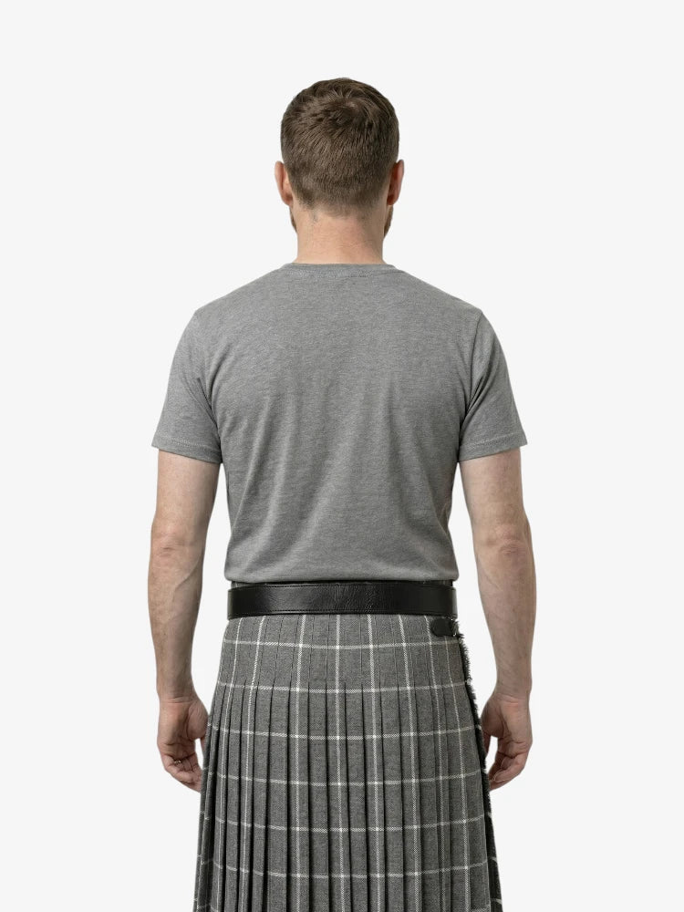 Man wearing a gray t-shirt and a gray plaid kilt on a white background