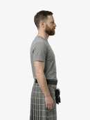 Man wearing a gray t-shirt and plaid kilt on a white background