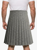 Person wearing a gray pleated skirt with a white shirt on a plain background
