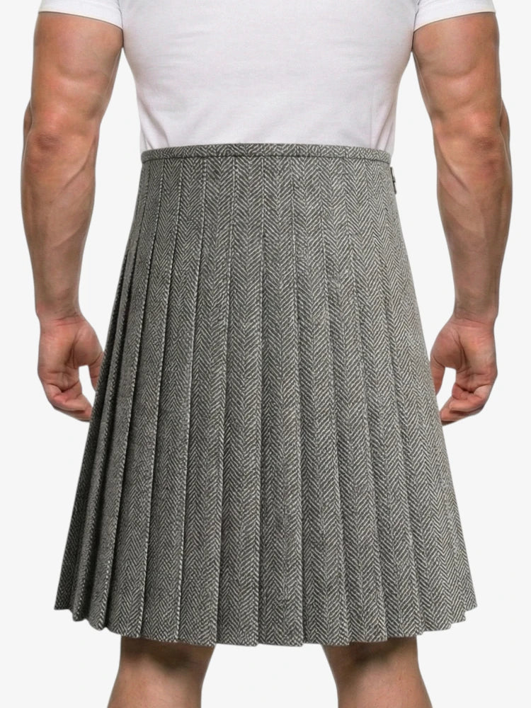 Person wearing a gray pleated skirt with a white shirt on a plain background