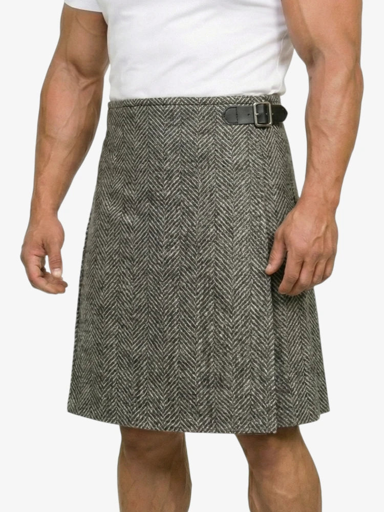 Person wearing a gray herringbone kilt on a white background