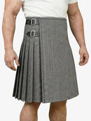 Person wearing a gray pleated kilt with a belt on a white background
