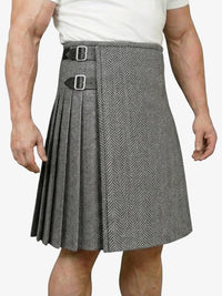 Person wearing a gray pleated kilt with a belt on a white background