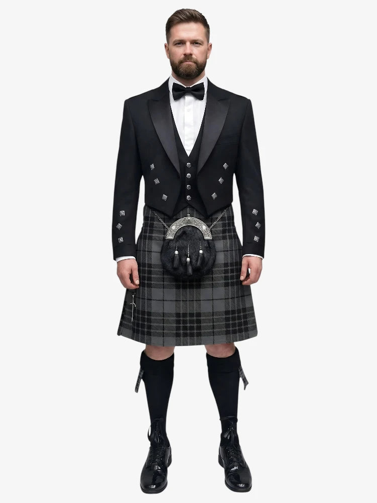 Man wearing a traditional Scottish grey watch tartan kilt with a black prince charlie jacket on a white background