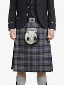 Person wearing a traditional Scottish kilt with a jacket on a white background