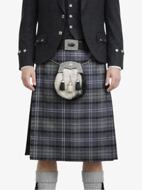 Person wearing a traditional Scottish kilt with a jacket on a white background
