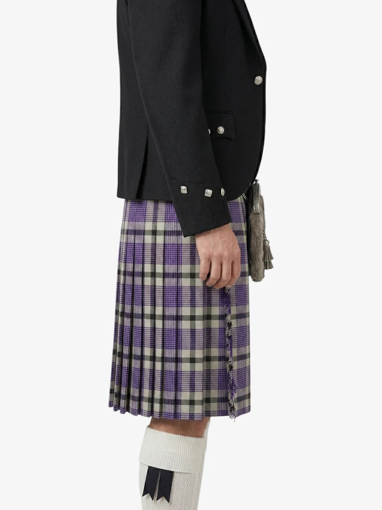 Person wearing a black jacket and purple plaid kilt on a white background