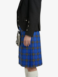 Person wearing a black blazer and blue plaid kilt on a white background