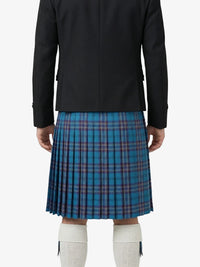 Person wearing a black jacket and blue plaid kilt on a white background