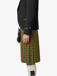 Person wearing a black jacket and green plaid kilt on a white background