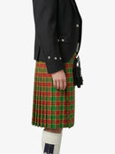 Person wearing a black jacket and green plaid kilt on a white background