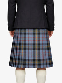 Person wearing a black jacket and plaid kilt on a white background