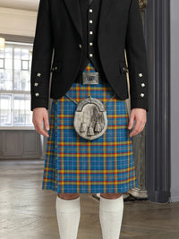 Person wearing a traditional Scottish kilt with a plaid pattern and a visible tartan emblem in an indoor setting.