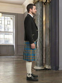 Man wearing a traditional Scottish kilt in an elegant interior setting