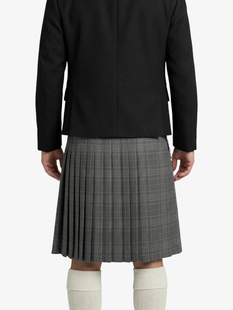 Person wearing a black blazer and gray pleated skirt on a white background