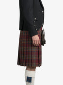 Person wearing a black jacket and red plaid kilt on a white background