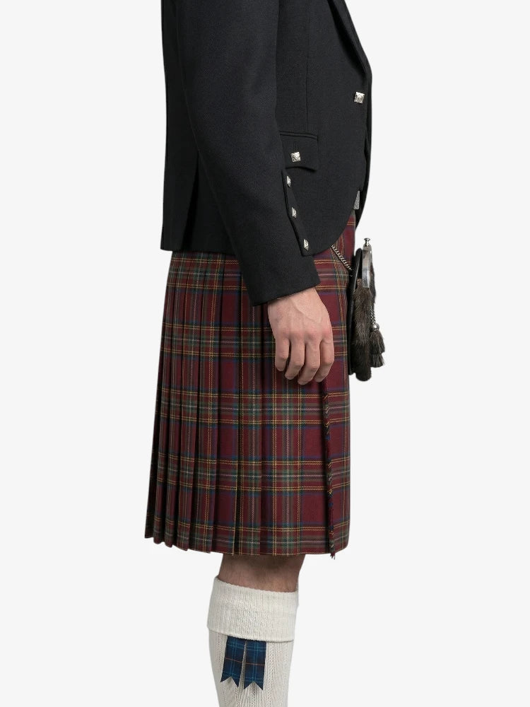 Person wearing a black jacket and red plaid kilt on a white background