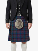 Person wearing a traditional Scottish kilt with a tartan pattern on a white background