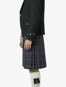 Person wearing a black jacket and plaid kilt on a white background