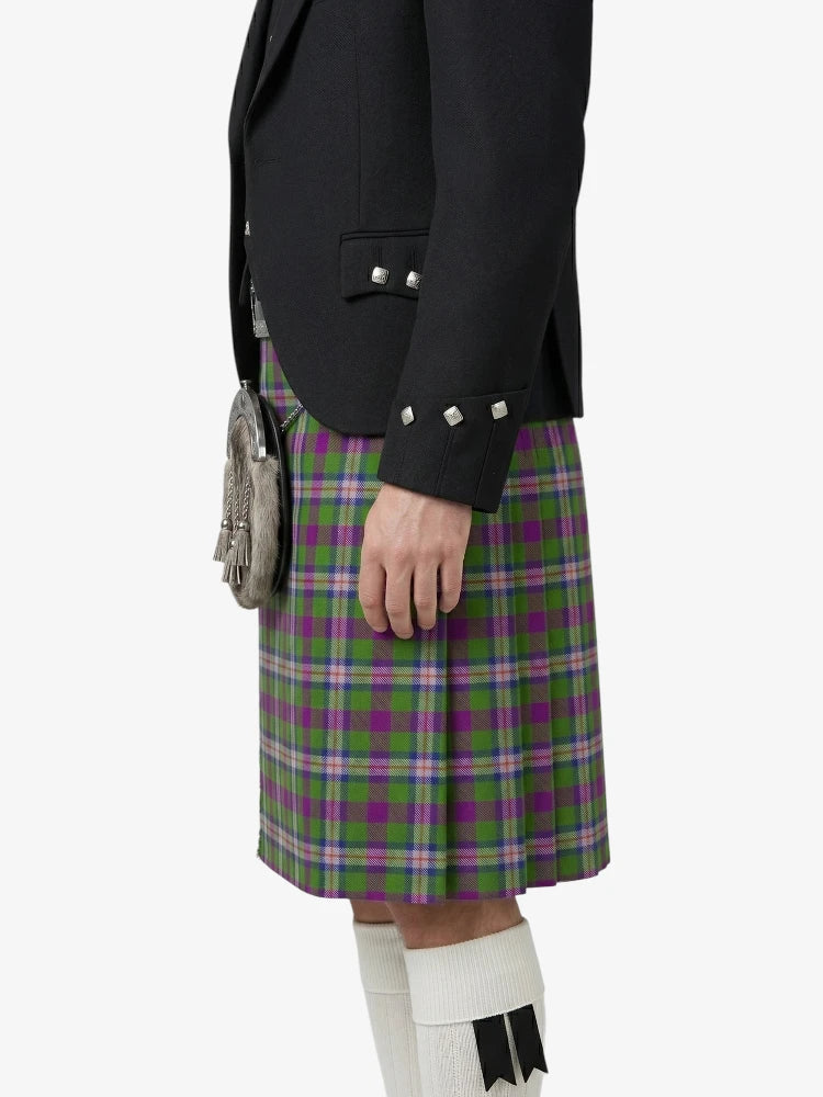 Person wearing a black jacket and green plaid kilt on a white background