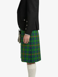 Person wearing a black jacket and green plaid kilt on a white background