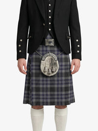 Person wearing a traditional Scottish kilt with a jacket on a white background