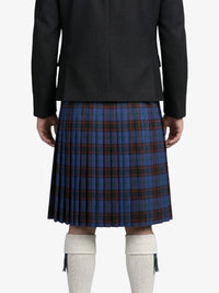 Person wearing a black coat and blue plaid kilt on a white background