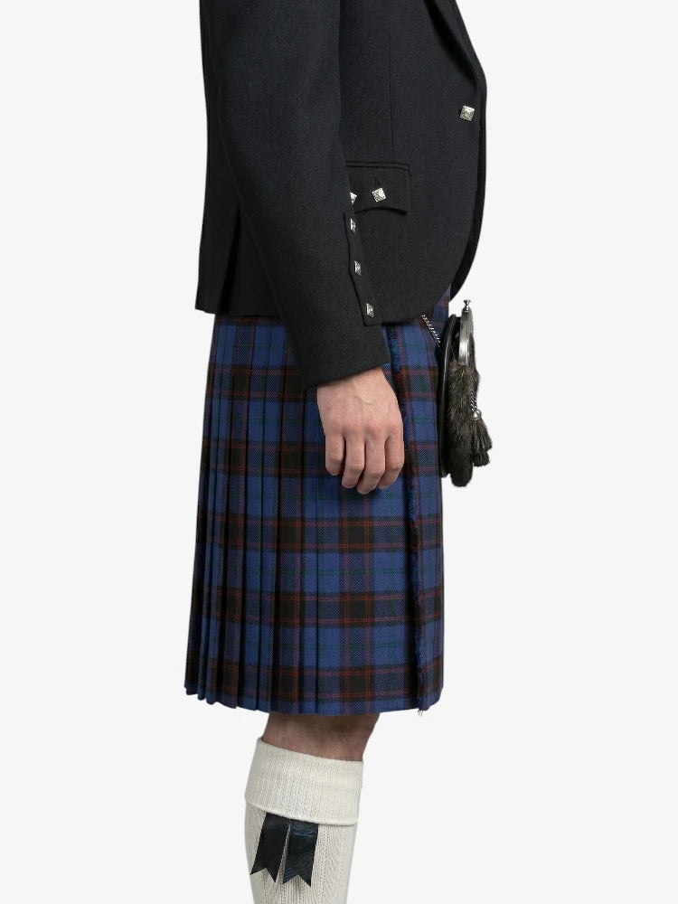 Person wearing a black jacket and blue plaid kilt on a white background