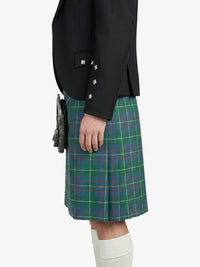 Person wearing a black jacket and green plaid kilt on a white background