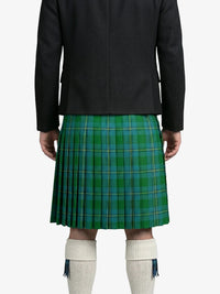 Person wearing a green plaid kilt with a black jacket on a white background