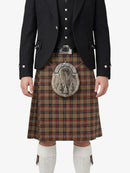 Person wearing a traditional Scottish kilt with a jacket on a white background