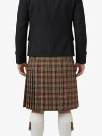 Person wearing a black jacket and plaid kilt on a white background