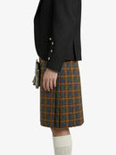 Person wearing a black jacket and plaid kilt on a white background