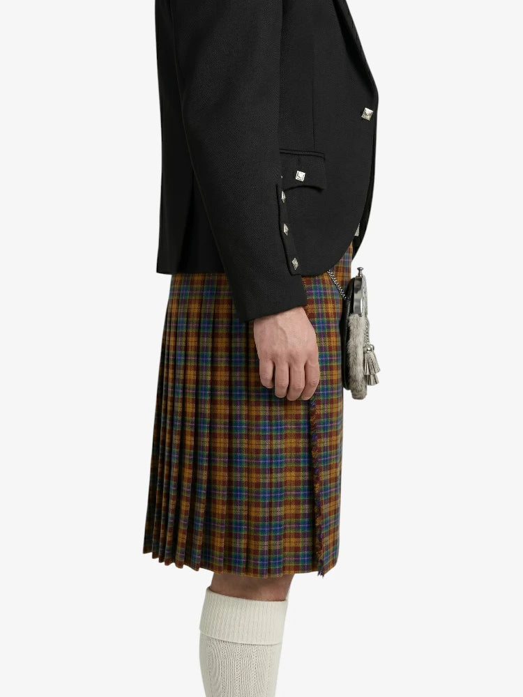 Person wearing a black blazer and plaid kilt on a white background
