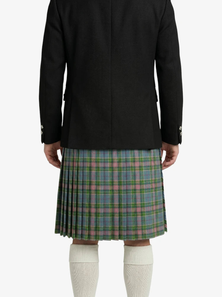 Person wearing a black jacket and plaid kilt on a white background