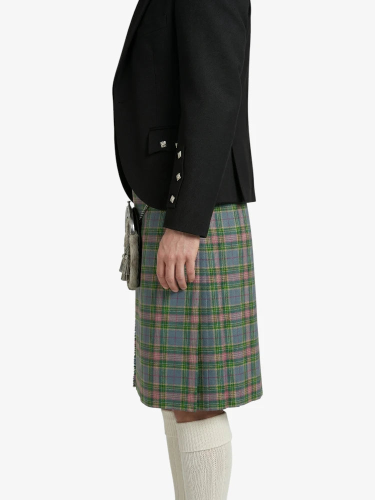 Person wearing a black jacket and plaid kilt on a white background