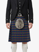 Person wearing a traditional Scottish kilt with a tartan pattern on a white background